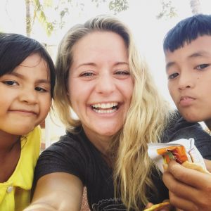 Sammy at an orphanage in Cambodia, with two adorable children
